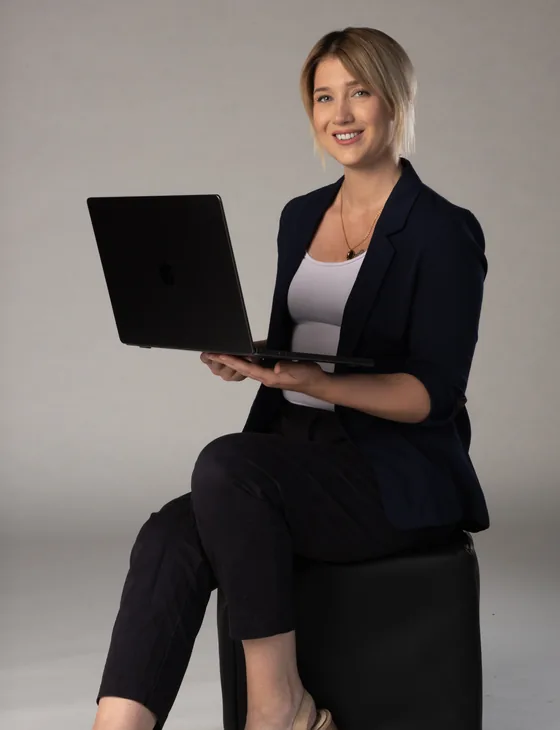 Monika sitzt mit einem Laptop auf dem Scho&szlig; und arbeitet